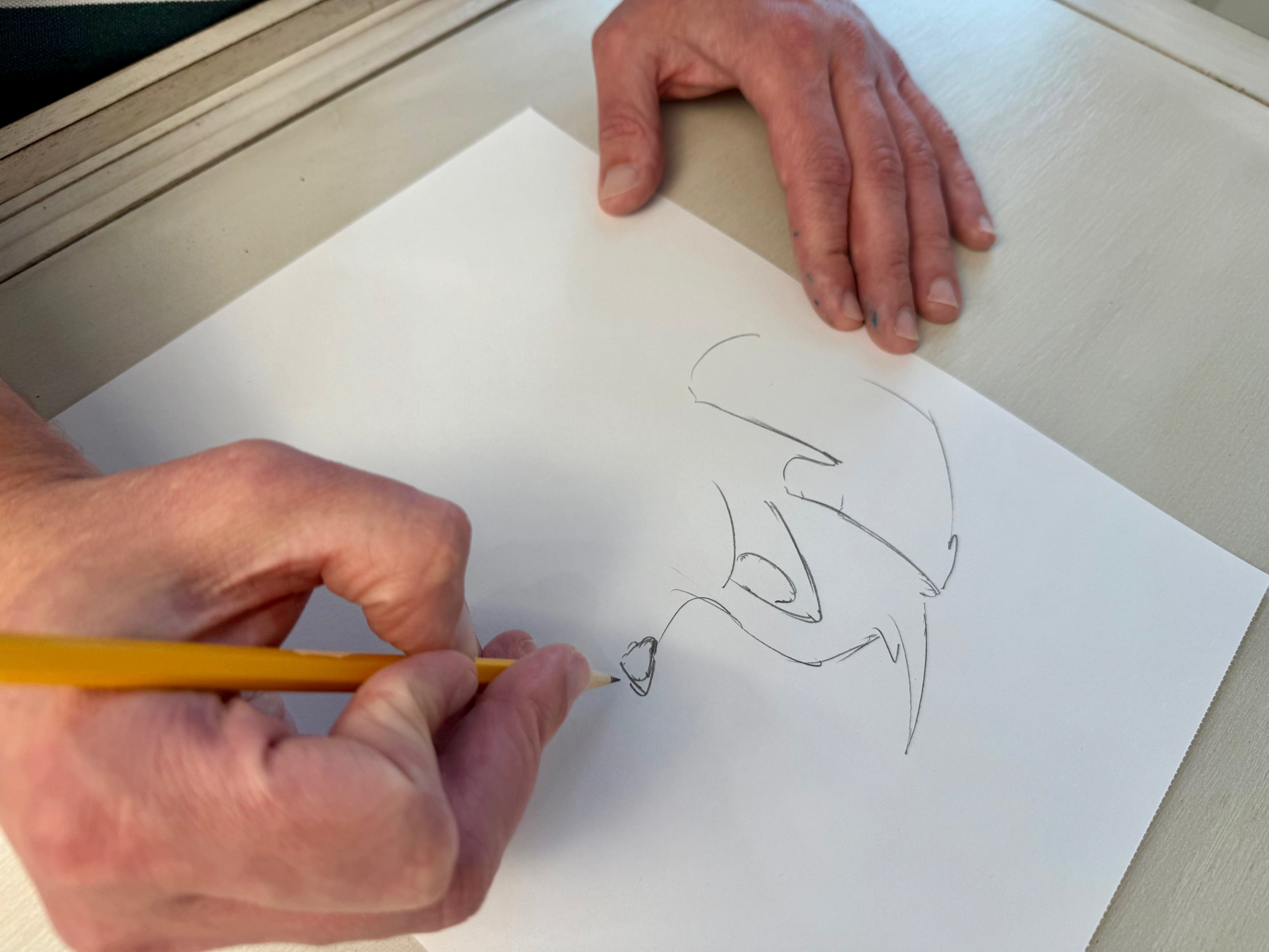 Benjamin King, creator of Prpl Up Pup, drawing Pup's face on a piece of paper with a pencil.