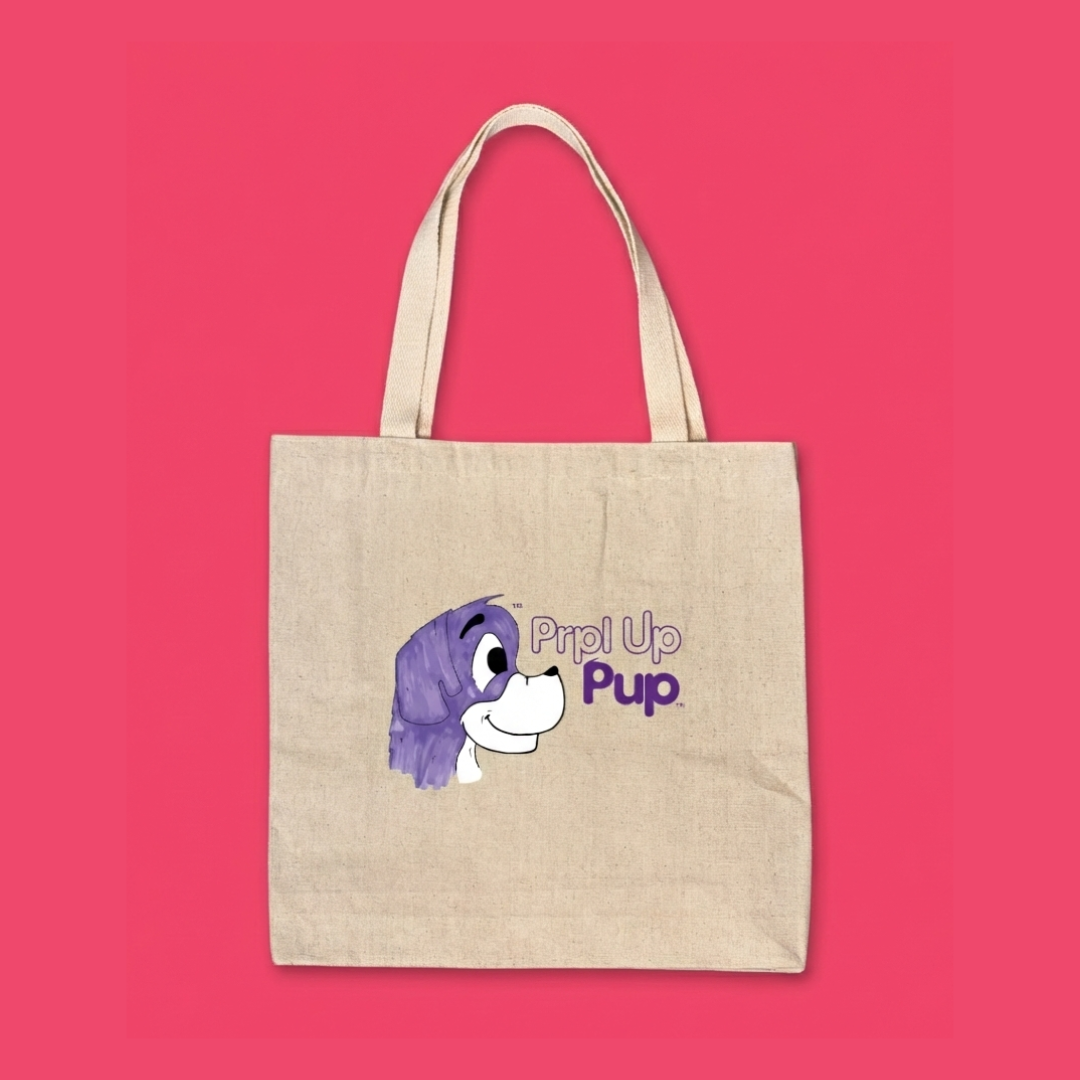 Canvas tote bag with a purple cartoon dog in a print design on a red background. This is the Prpl Up Pup logo which is the storytelling children's brand for kids 3 to 8.