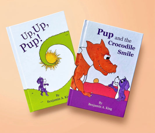 Two children's picture books, 'Up, Up, Pup!' and 'Pup and the Crocodile Smile' by Benjamin A. King, displayed on a warm beige background.