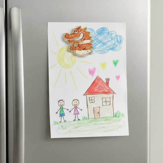 Colorful drawing of a house, two children, and a crocodile on a refrigerator. An acrylic magnet inspired by the Prpl Up Pup world.