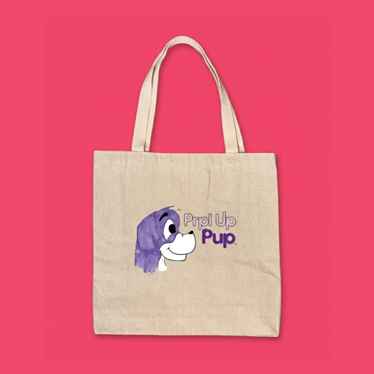 Canvas tote bag with a purple cartoon dog in a print design on a red background. This is the Prpl Up Pup logo which is the storytelling children's brand for kids 3 to 8.