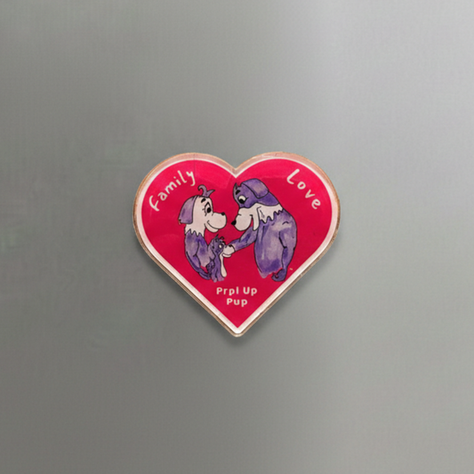 Heart-shaped acrylic magnet with purple cartoon dogs and text on a gray surface. This is the Prpl Up Pup family.